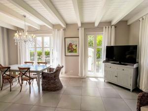 a dining room with a table and a tv at Ferienhaus Malve in Liepe +10 photos