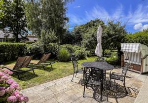a patio with a table and chairs and an umbrella at Ferienhaus Malve in Liepe
