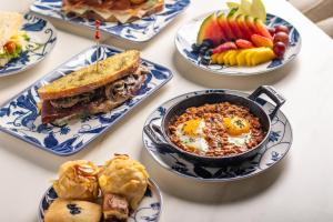 a table topped with plates of food with a sandwich at Berthas Collection By EM Hotels in Cartagena de Indias