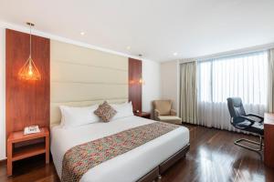 a hotel room with a bed and a chair at Hotel Andes Plaza in Bogotá
