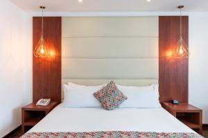 a bedroom with a white bed with two night stands at Hotel Andes Plaza in Bogotá