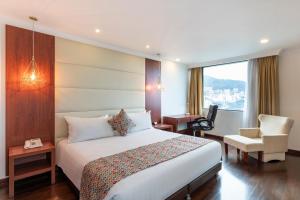 a hotel room with a bed and a chair and a window at Hotel Andes Plaza in Bogotá