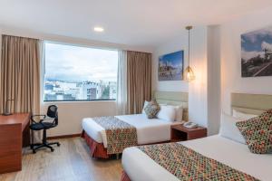 a hotel room with two beds and a window at Hotel Andes Plaza in Bogotá
