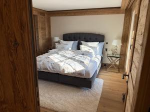 a bedroom with a large bed with white sheets and pillows at Petite Fraise in Gstaad