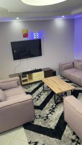a living room with two couches and a flat screen tv at Manja Homes in Ruiru