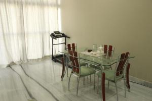 a glass table and chairs in a room with a window at Ratan Vilas in Jaipur