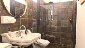 a bathroom with a sink and a toilet and a mirror at Mosel-Side De Luxe Suite in Reil