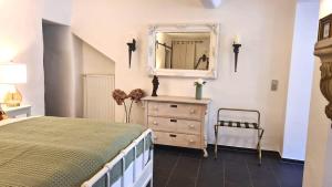 a bedroom with a bed and a dresser with a mirror at Mosel-Side De Luxe Suite in Reil