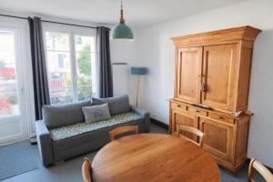 a living room with a couch and a table at Maison spacieuse au coeur du Centre - Plage à pied in Luc-sur-Mer