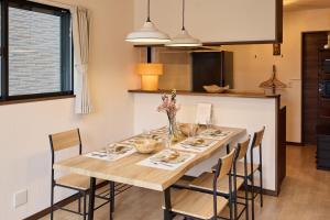 a dining room with a wooden table and chairs at 宿 花甜 in Osaka