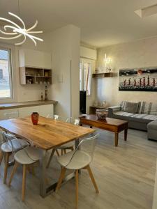 a kitchen and living room with a wooden table and chairs at A casa di Ada in Finale Ligure