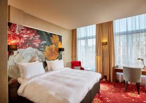 ein Hotelzimmer mit einem großen Bett und einem Schreibtisch in der Unterkunft Carlton Ambassador in Den Haag