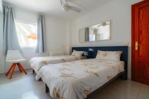 a bedroom with two beds and a mirror and a window at Apartamentos Mallorca SL in Cala Millor +58 photos