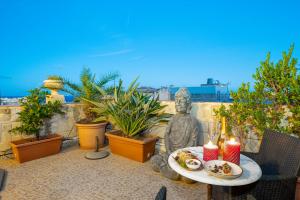 a statue sitting on a patio with a table with food at Valletta Apartments 19 in Valletta
