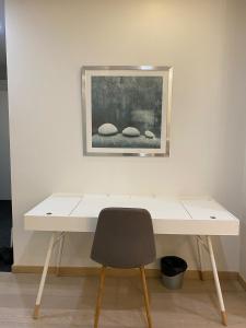 a desk with a chair and a painting on the wall at Gella Munkkisaarenkatu 2 in Helsinki