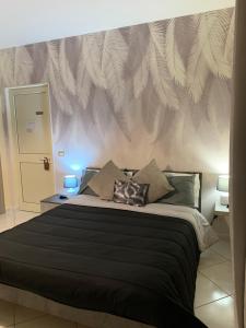 a bedroom with a large bed with a leafy wall at Tenuta degli Uliveti in SantʼElia Fiumerapido