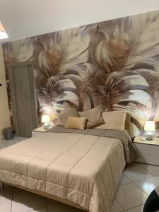 a bedroom with a large bed with a painting on the wall at Tenuta degli Uliveti in SantʼElia Fiumerapido