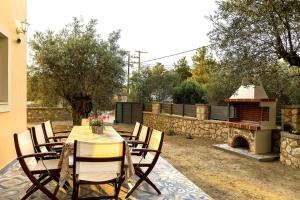 a patio with a table and chairs and a fireplace at Lindos Luxury Retro Villas in Lindos