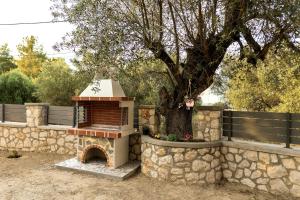 a stone wall with a brick fireplace in front of a tree at Lindos Luxury Retro Villas in Lindos +32 photos
