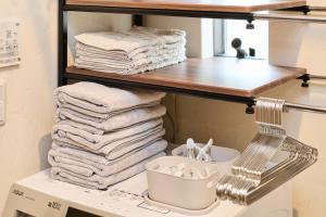 a pile of towels on a shelf in a bathroom at 宿 花甜 in Osaka +35 photos