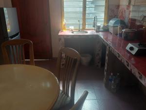 a kitchen with a table and a sink and a counter at Sumud Bonda Homestay in Kuala Kerai