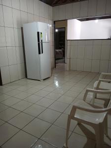 a room with a refrigerator and a chair in it at Férias da Hora in Prado