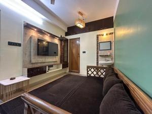 a living room with a couch and a television at Zen Luxe Abode in Siliguri