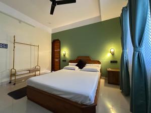 a bedroom with a bed and a green wall at Zen Luxe Abode in Siliguri