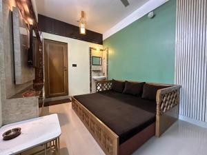 a bedroom with a bed and a couch in a room at Zen Luxe Abode in Siliguri