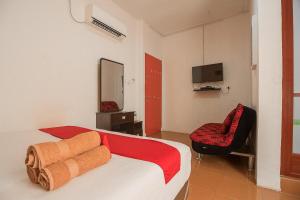a bedroom with a bed and a chair and a television at RedDoorz @ Batam Center 2 in Batam Center