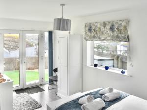 a white bedroom with a bed and a window at Seagulls View in Brixham +3 photos
