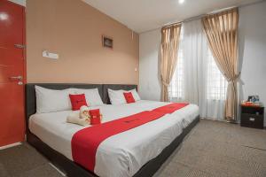 a bedroom with a large bed with red and white pillows at RedDoorz @ Batam Center 2 in Batam Center +12 photos