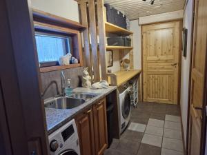 a kitchen with a sink and a washing machine at Villa Vonkale in Äänekoski +31 photos