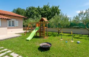 a playground with a slide and a swing set in a yard at Gorgeous Home In Rovinj in Rovinj