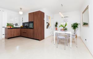 a kitchen and dining room with a table and cabinets at Gorgeous Home In Rovinj in Rovinj