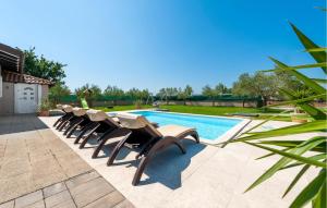 a row of lounge chairs next to a swimming pool at Gorgeous Home In Rovinj in Rovinj +27 photos
