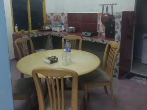 a table and chairs with a bottle of water on it at Sumud Bonda Homestay in Kuala Kerai