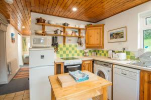 a kitchen with a white refrigerator and a dishwasher at 1 Caerau Isaf in Haverfordwest +26 photos