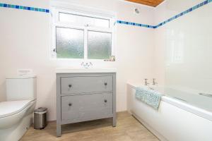 a bathroom with a sink and a tub and a toilet at 1 Caerau Isaf in Haverfordwest
