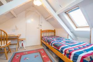 a bedroom with a bed and a desk and a window at 1 Caerau Isaf in Haverfordwest