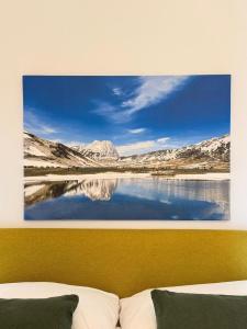 a painting of a lake with mountains in the background at MECE Rooms in LʼAquila