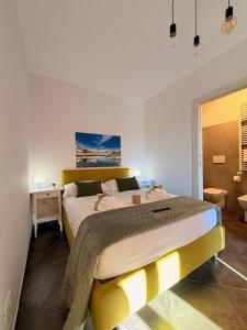 a bedroom with a large bed with a yellow headboard at MECE Rooms in LʼAquila
