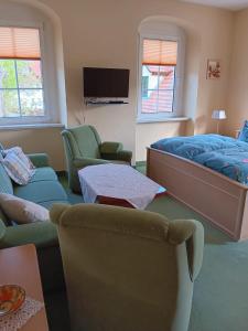 a living room with a bed and a couch and chairs at Barthmühle in Klipphausen