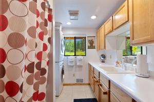 a kitchen with a refrigerator and a sink at The Meadowlark Cabin in Big Arm +73 photos