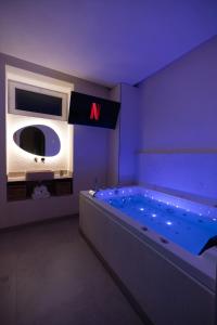 a room with a large tub with a letter on it at La Suite Grecque in Mitry-Mory