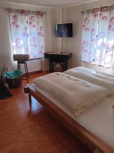 a bedroom with two beds and a table and two windows at Barthmühle in Klipphausen