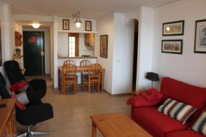 a living room with a red couch and a table at Deltamar Solo Familias Serviplaya in Xeraco