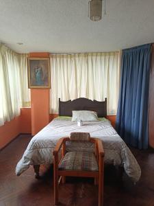 a bedroom with a large bed with blue curtains at La Casa Junto Al Rio in Arequipa