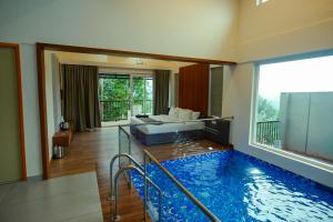 a large swimming pool in a living room with a couch at Ymoon Mountain Resort Wayanad in Koroth