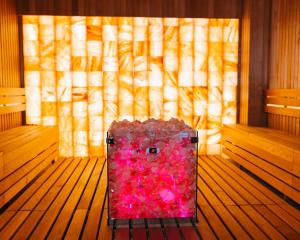 a pink suitcase sitting in the middle of a room at Planet Imperial Apartman & SPA in Niš